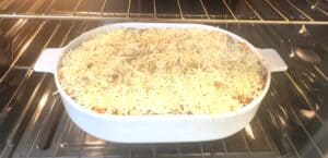 Cheesy casserole baking in the oven in a white dish for a delicious homemade dinner.